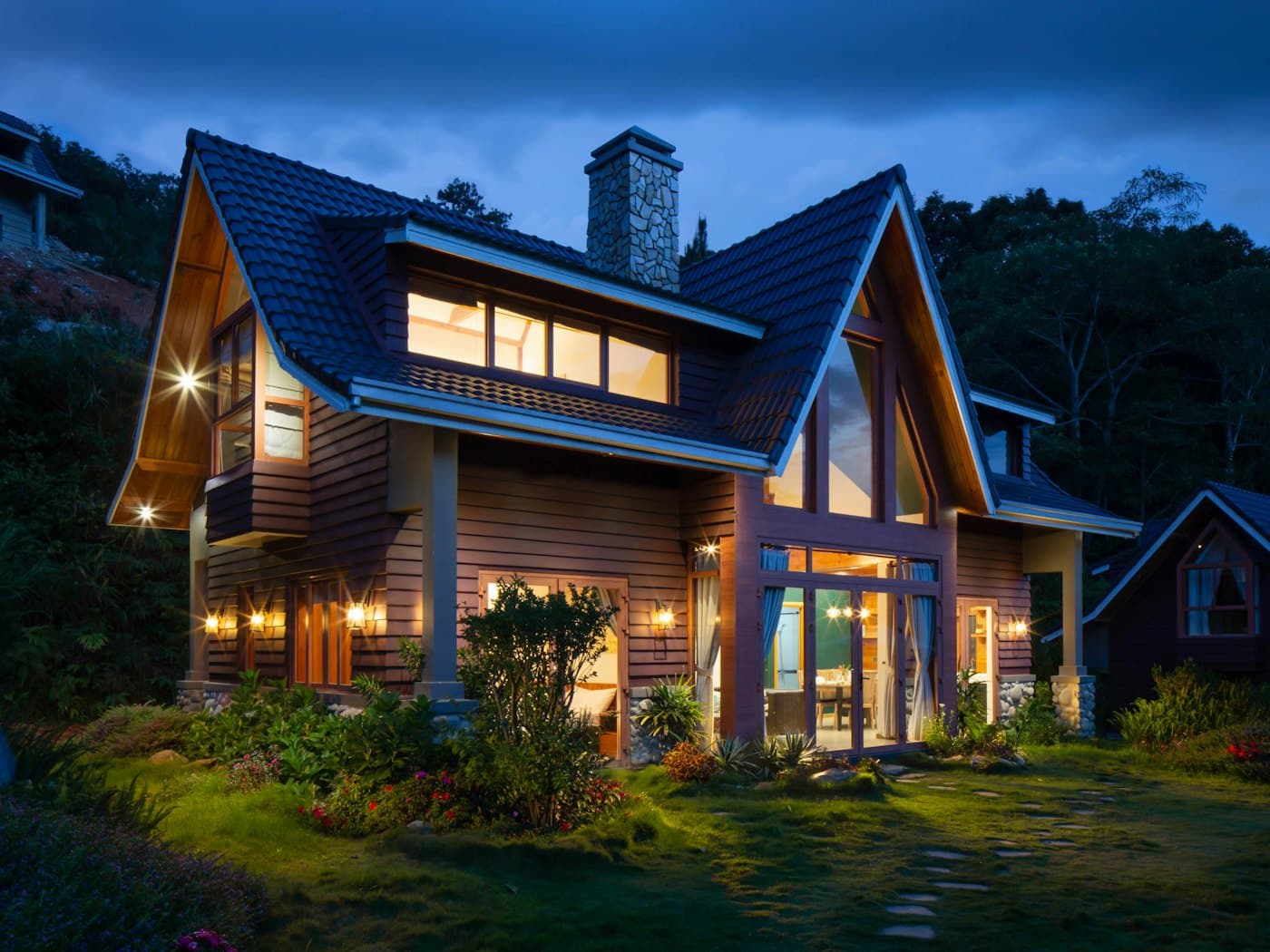 A timber-framed family home lit up at dusk